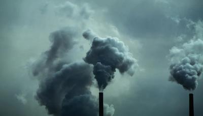 Smokestacks against a blue sky, industrial landscape.
