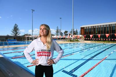 Woman with dark hair, smiling, in front of a blurred background.