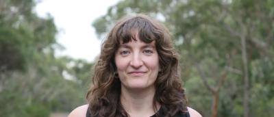 Headshot of Piper Rollins, smiling, against a blurred background.