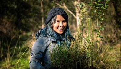 Volunteer with a smiling face, wearing a hat, outdoors.