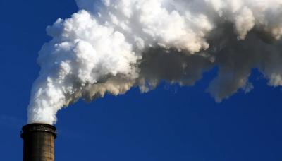 Coal stack against a blue sky, industrial landscape.