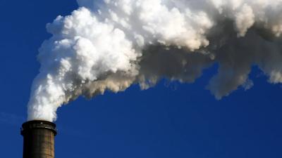 Coal stack against a blue sky, industrial landscape.