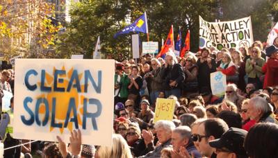 Woman with short hair, smiling, holding a sign that says "Say Yes