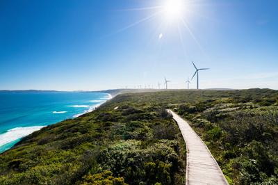 Albany Wind Farm, multiple wind turbines on a green hillside, blue sky.