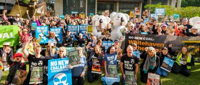 Protest rally against Whitehaven Coal. People holding signs, some with flags.