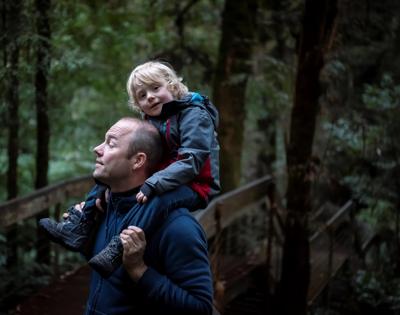 Man holding child on shoulders, outdoors.