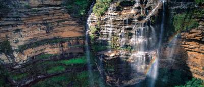 Scenic view: Wentworth Falls, Katoomba. Mountains, trees, waterfall, blue sky.