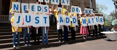 A person in action, possibly protesting or advocating, with a sign.