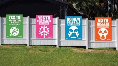 Placards on a wall, various colors and text.