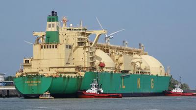 Large ship sailing on ocean, blue sky, white clouds.