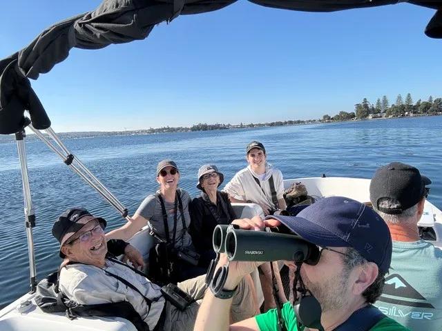 Birders with binoculars scanning the boats moored at Marks Point