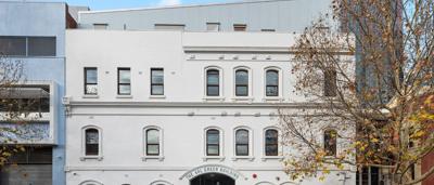 Victorian terrace house, 60 Leicester Street, Carlton, Melbourne. Brick facade, iron lacework, street view.