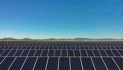 Solar farm in Queensland, Australia. Array of solar panels under a blue sky.