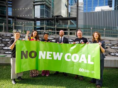 Protest rally against Whitehaven Coal. People holding signs, some with flags.