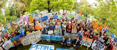 Protest sign against Adani, crowd, banner, Australian flag.