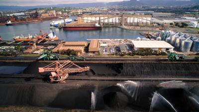 Port Kembla Coal Terminal, NSW. Large coal piles, conveyor belts, industrial landscape.