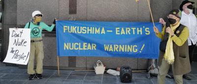 Nuclear plant, damaged buildings, smoke, and a cloudy sky.