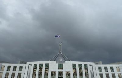 Parliament House, Canberra. Australian flag flying, blue sky.