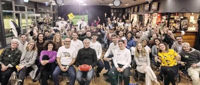AFL players in action, green field, sunny day, climate change message on screen.