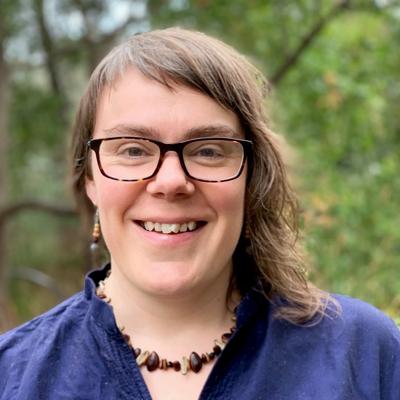 Woman smiling, outdoor portrait, blonde hair, natural light.