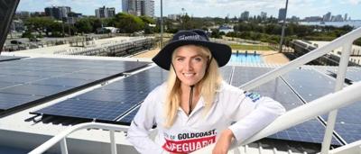 Solar panel array on a roof, blue sky background.