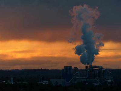 Pollution header image: smog over city skyline, industrial chimneys emitting smoke.