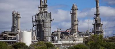 Offshore oil rig, blue ocean, cloudy sky, Woodside logo.