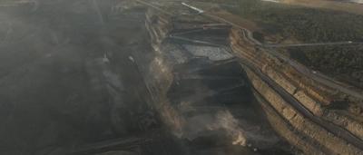Open-cut coal mine, large machinery, vast landscape, dusty environment.