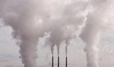 Pollution image: Smoke stacks, smog, industrial landscape, hazy sky.