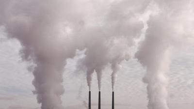 Pollution image: Smoke stacks, smog, industrial landscape, hazy sky.