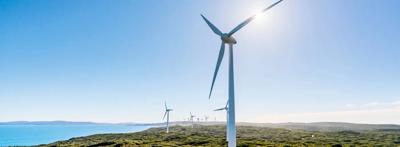 Header image: Wind turbines and solar panels on a sunny day, representing renewable energy.