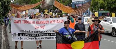 Toondah Harbour rally image. People, boats, and banners.