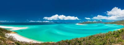 Queensland beach header image: blue ocean, sandy shore, clear sky, distant horizon.