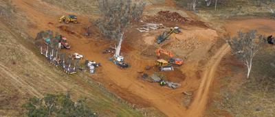 Land cleared, machinery present. Brown earth, trees, and equipment.