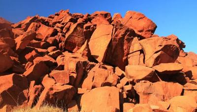 Rock art panel, red ochre figures, Murujuga, Western Australia.