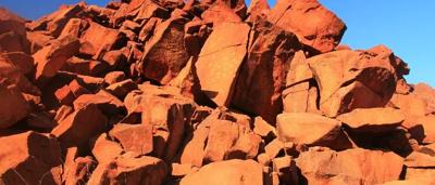Rock art panel, red ochre figures, Murujuga, Western Australia.