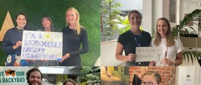Woman smiling, holding solar panel, green field, sunny day.