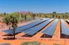 Outback solar farm, vast array of panels under a blue sky.