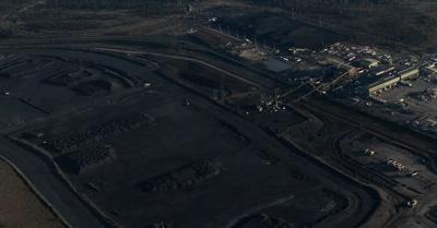 Hail Creek mine landscape, large open-cut pit, machinery, blue sky, clouds.