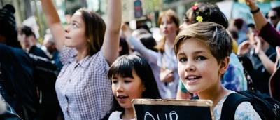 School strike protest sign, climate action, crowd, holding signs.
