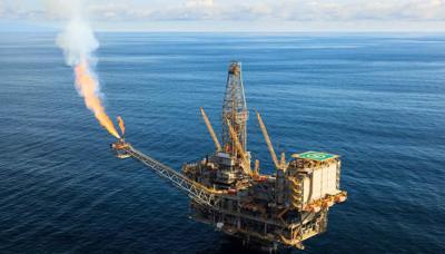 Offshore gas platform emitting smoke, polluting the ocean and sky.