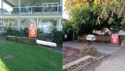 Woman in a white shirt, smiling, holding a phone, with a blurred background.