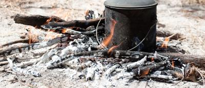 Man sitting by campfire, Olkola country.