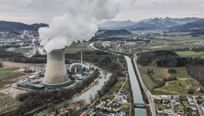 Nuclear power plant header image. Cooling towers, power lines, and a blue sky.